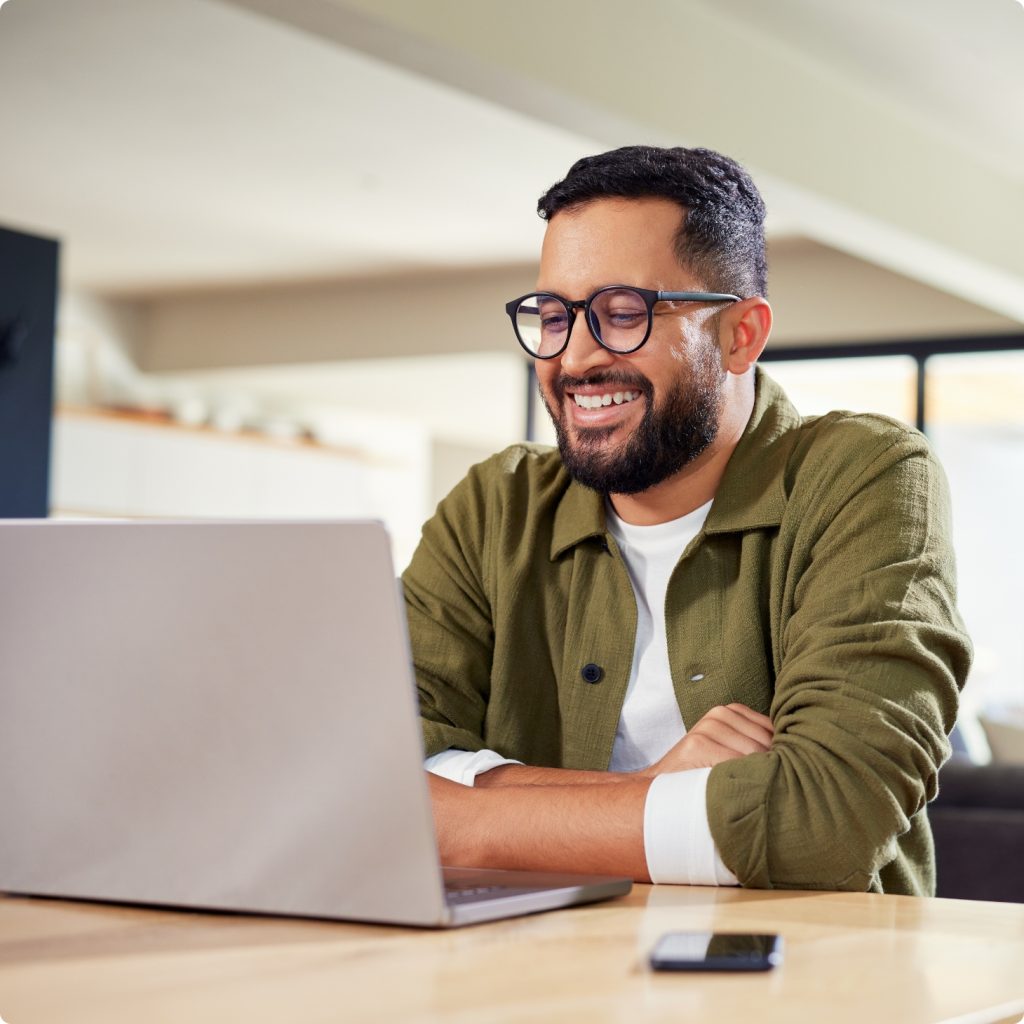 man smiling at laptop