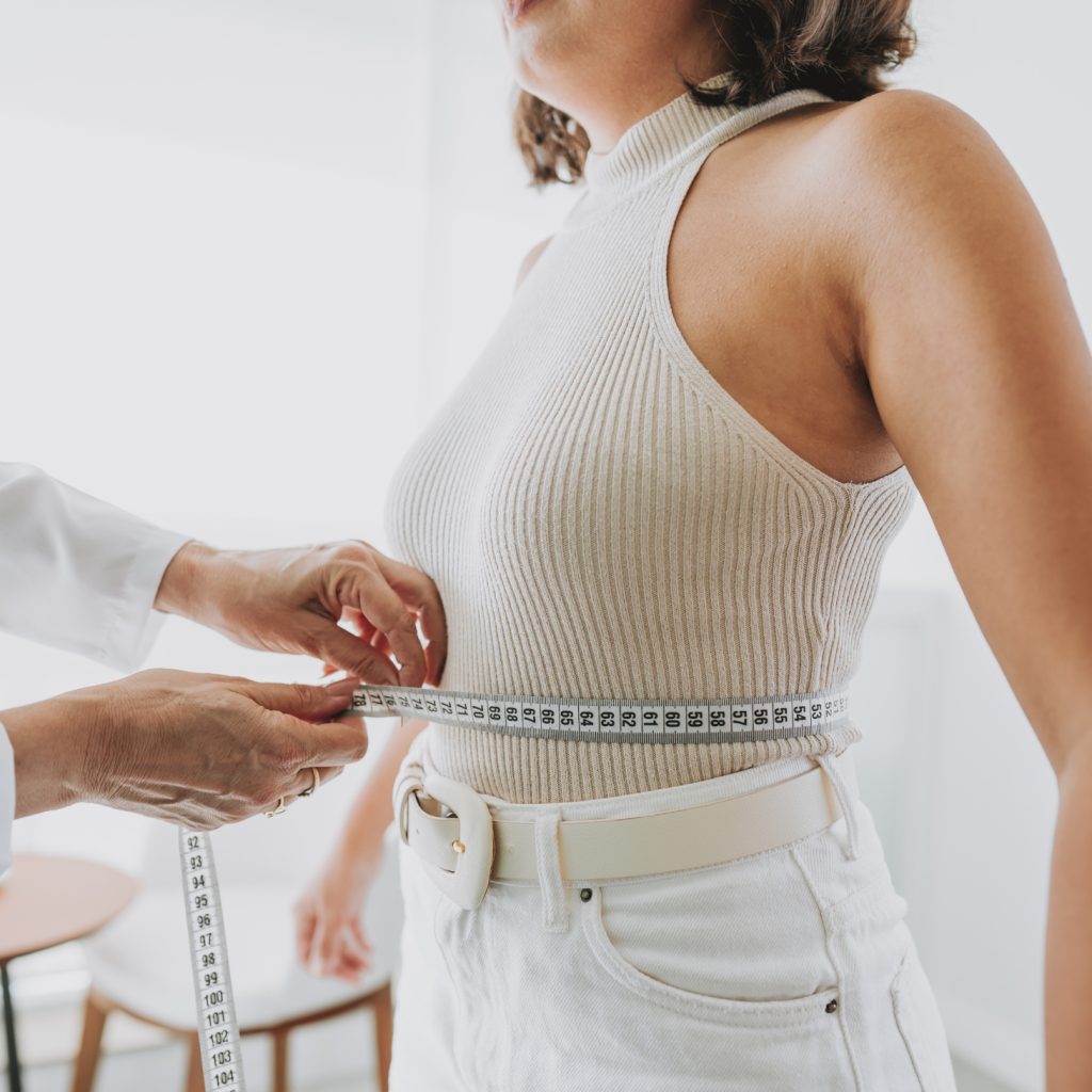 close up of woman's waist being measured